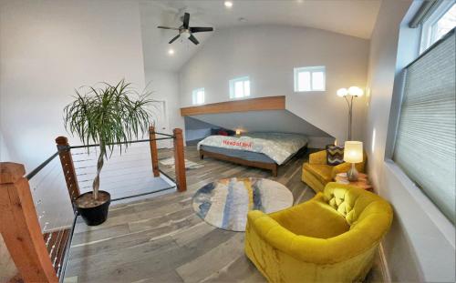 a living room with a yellow chair and a bed at The Elm Tree Cottage in the Sugarhouse District in Salt Lake City