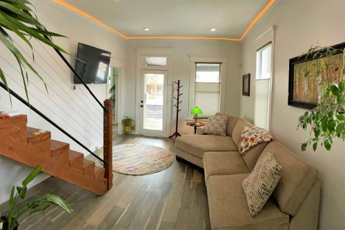ein Wohnzimmer mit einem Sofa und einer Treppe in der Unterkunft The Elm Tree Cottage in the Sugarhouse District in Salt Lake City