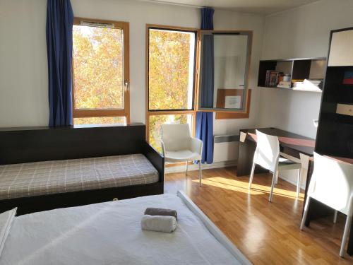 1 dormitorio con cama, escritorio y mesa en Studio lumineux 10 min à La Défense en Rueil-Malmaison