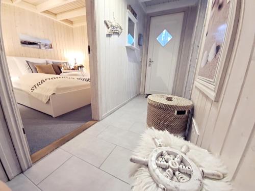 a bedroom with a bed and a room with a mirror at Strandhaus Rügen - Meerblick, Sauna, Kamin & Whirlpool in Baabe