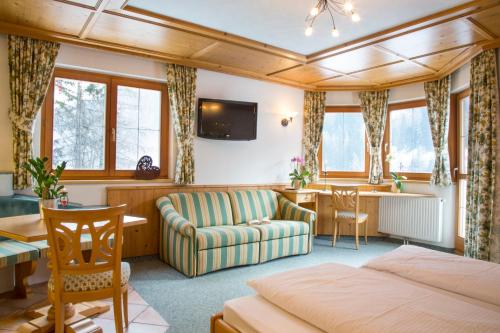 sypialnia z łóżkiem, kanapą i biurkiem w obiekcie Fliana Arlberg Studios & Apartments w mieście Sankt Anton am Arlberg