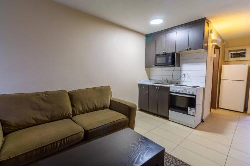 a living room with a couch and a kitchen at North Star Inn & Suites in Prince George