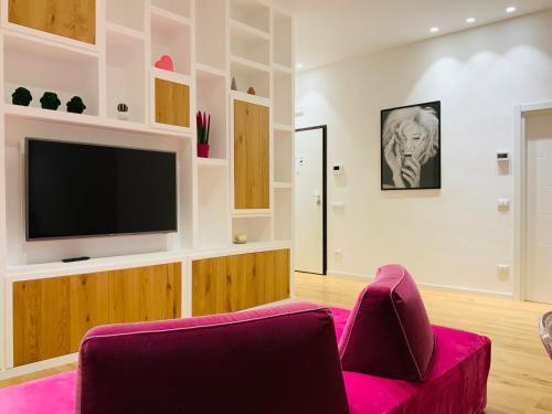 a living room with a tv and a purple chair at NIMA Boutique House in Perugia