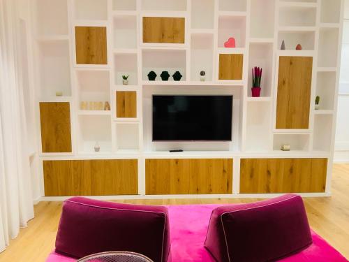 a living room with a tv on a wall at NIMA Boutique House in Perugia