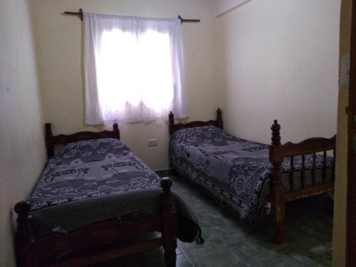 a bedroom with two beds next to a window at Hospedaje Ale in Iruya