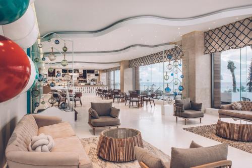 un vestíbulo con sofás y mesas y un bar en Coral Level en Iberostar Selection Cancun, en Cancún