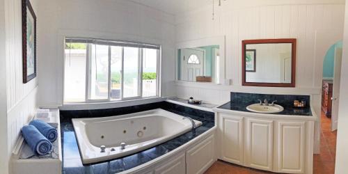 a large bathroom with a tub and a sink at OceanFront Kauai - Harmony TVNC 4247 in Kapaa