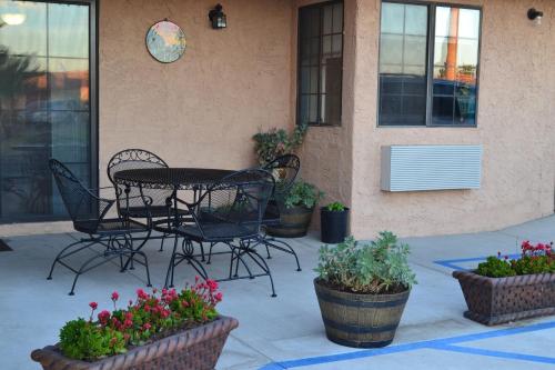 a patio with a table and chairs and potted plants at El Rancho Dolores at JT National Park in Twentynine Palms