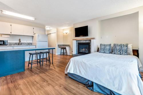 a bedroom with a bed and a kitchen with a fireplace at Bend Riverside Condos Near Downtown Bend in Bend