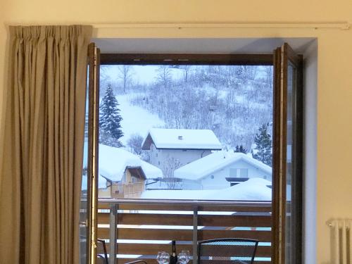 a view of a snow covered yard from a window at Residence Aurora in Lavarone