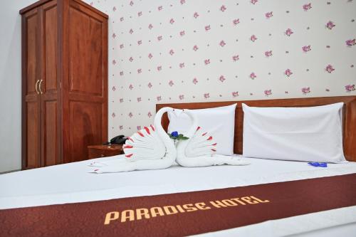 two white shoes are sitting on a bed at Paradise Hotel in Củ Chi