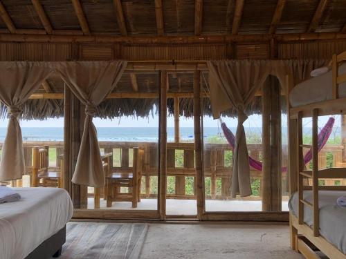 a bedroom with a view of the ocean at Cabalonga EcoAdventure in Puerto Cayo