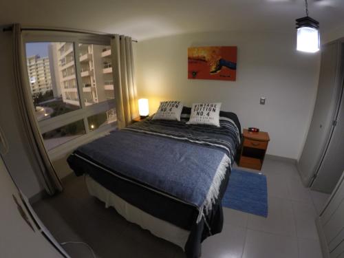 a bedroom with a bed and a large window at Central de Arriendos Nueva Serena in La Serena