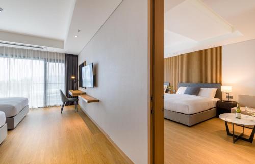 a hotel room with a bed and a table at The Grand Sumorum in Seogwipo