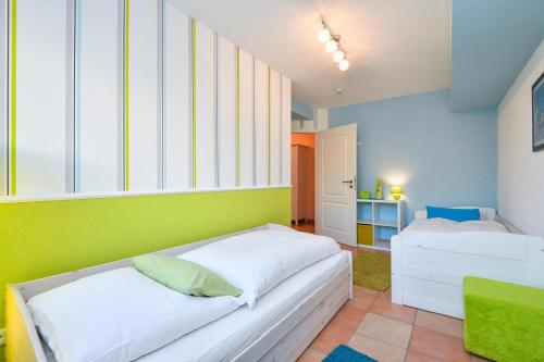 1 Schlafzimmer mit 2 Betten und grünen und blauen Wänden in der Unterkunft Villa Hoffnung Wohnung 3 in Kellenhusen
