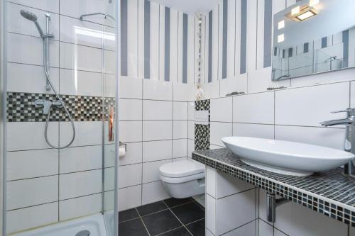 ein weißes Bad mit einem Waschbecken und einem WC in der Unterkunft Villa Hoffnung Wohnung 3 in Kellenhusen