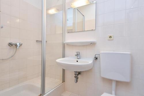 een badkamer met een toilet, een wastafel en een douche bij Ferienwohnung Ostsee-Hecht mit Balkon im Kaiserhof 2 in Kellenhusen