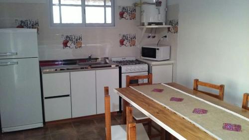 a kitchen with white appliances and a table with chairs at La Solita in Chajarí