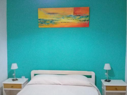 1 dormitorio azul con 1 cama y 2 mesitas de noche en La Solita en Chajarí