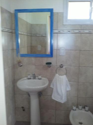 a bathroom with a sink and a mirror and a toilet at La Solita in Chajarí
