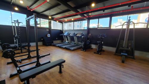 a gym with several treadmills and elliptical machines at Benikea Hotel Yangsan in Yangsan