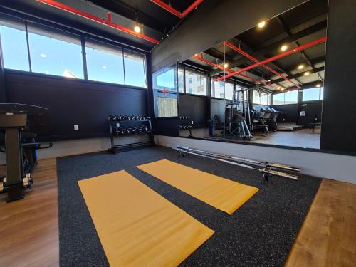 a gym with yellow mats in a room with windows at Benikea Hotel Yangsan in Yangsan
