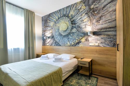 ベロクリハにあるОтель "Белокуриха"の壁画のベッドが備わるホテルルームです。