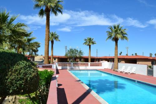 a swimming pool with palm trees in a resort at El Rancho Dolores at JT National Park in Twentynine Palms