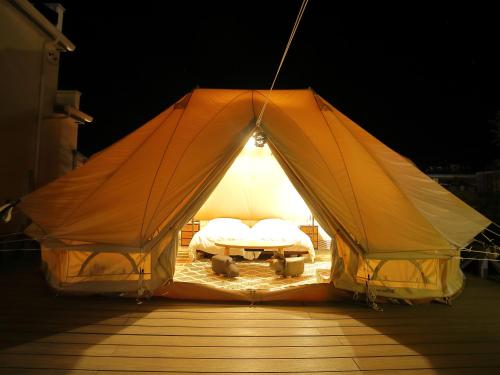 une tente avec un lit et une table. dans l'établissement Fukiagehama Field Hotel, à Ichikikushikino