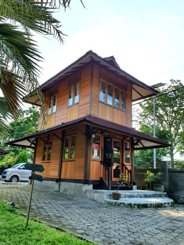 a wooden house on a street with a car at HOTEL BESAR BULAN BARU - Senggigi in Senggigi 