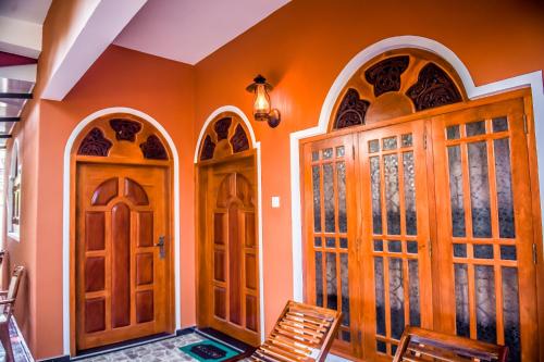 um quarto com duas portas e uma cadeira em Blue Birds Tissa & Yala safari em Tissamaharama