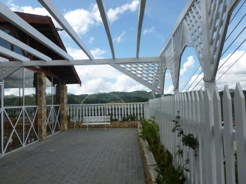 a balcony with a bench and a fence at Pousada dos Esquilos in Campos do Jordão