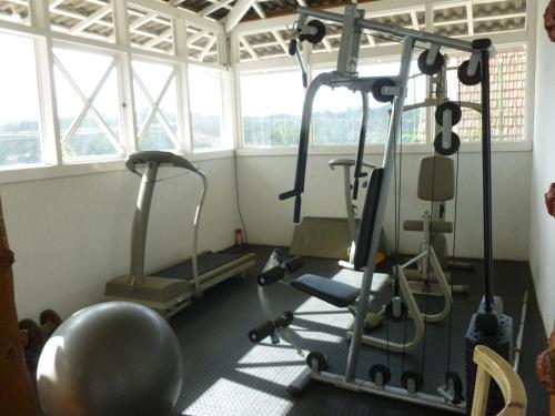 a gym with two exercise bikes in a room with windows at Pousada dos Esquilos in Campos do Jordão