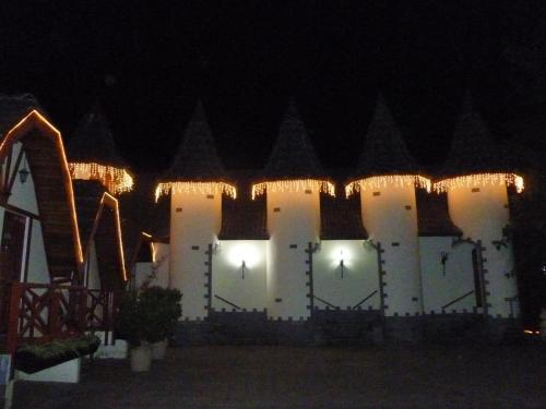 a white building with lights on it at night at Pousada dos Esquilos in Campos do Jordão