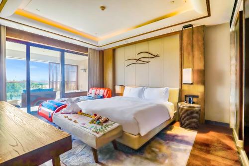 - une chambre avec un grand lit et une grande fenêtre dans l'établissement InterContinental Sanya Haitang Bay Resort, an IHG Hotel, à Sanya