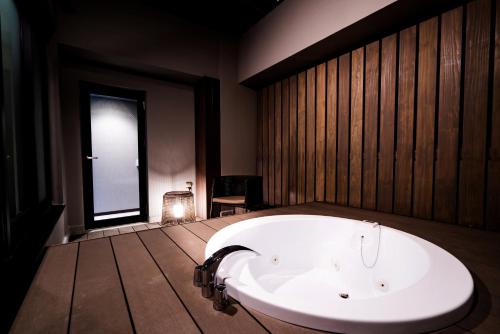 a large bath tub in a room with a window at Randor Hotel Namba Osaka Suites in Osaka