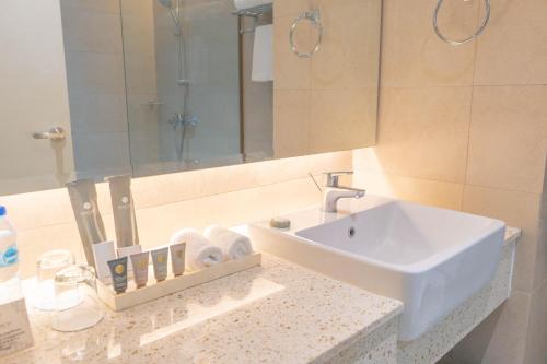y baño con lavabo y espejo. en The Monarch Hotel en Calasiao
