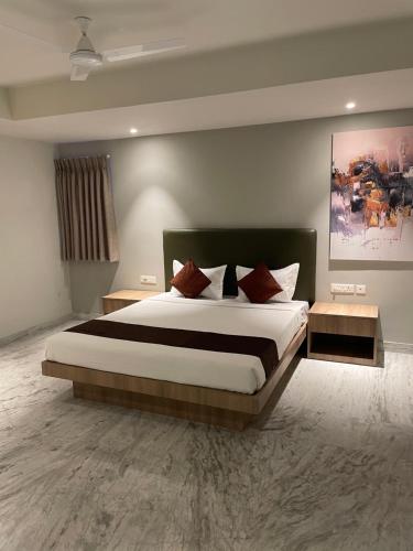 a bedroom with a large bed and two tables at Hotel The Crest in Kolkata