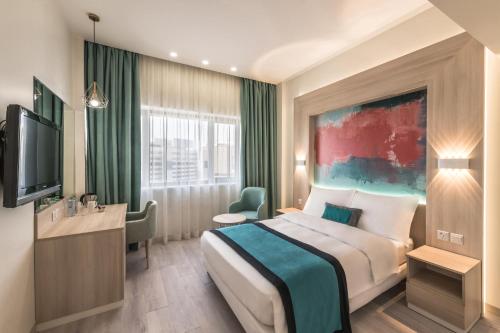 a hotel room with a bed and a television at Oasis Hotel in Kuwait