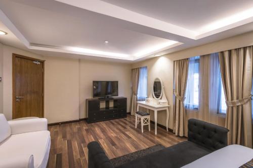 a hotel room with a bed and a tv and a couch at Oasis Hotel in Kuwait