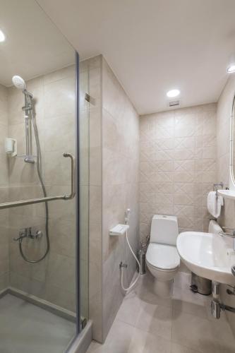 a bathroom with a shower and a toilet and a sink at Oasis Hotel in Kuwait