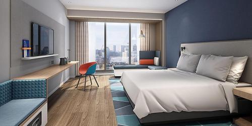 um quarto de hotel com uma cama grande e uma secretária em Holiday Inn Express Shanghai Baoyang, an IHG Hotel em Baoshan