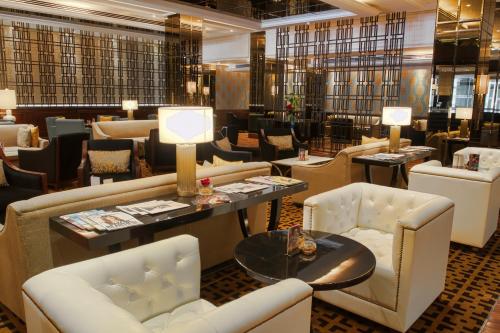 a restaurant with couches and tables and chairs at InterContinental Bahrain by IHG in Manama