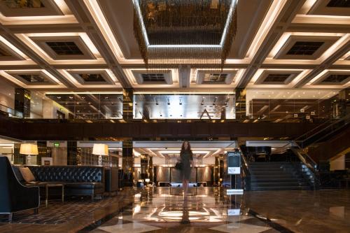 InterContinental Bahrain, an IHG Hotel في المنامة: لوبي فندق فيه درج ومبنى