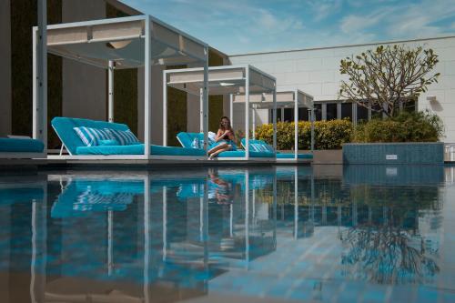InterContinental Bahrain, an IHG Hotel في المنامة: وجود امرأة جالسة على طوف في حمام السباحة
