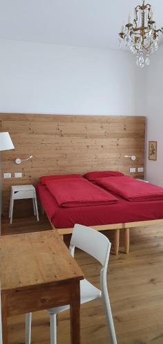 um quarto com uma cama vermelha e uma mesa em B&B Panemiele em Sondrio