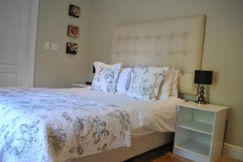 a bedroom with a large white bed with pillows at Apartment Jourdan in Franschhoek