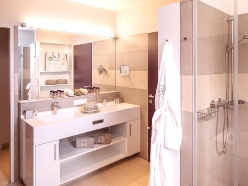 a bathroom with a sink and a shower at Narzissen Vital Resort Bad Aussee in Bad Aussee