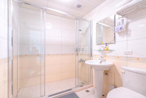 a bathroom with a shower and a toilet and a sink at 林居民宿 in Jinhu