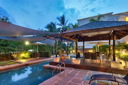a backyard with a swimming pool and a house at Tropical One Bedroom Apartment at The Mediterranean in Port Douglas